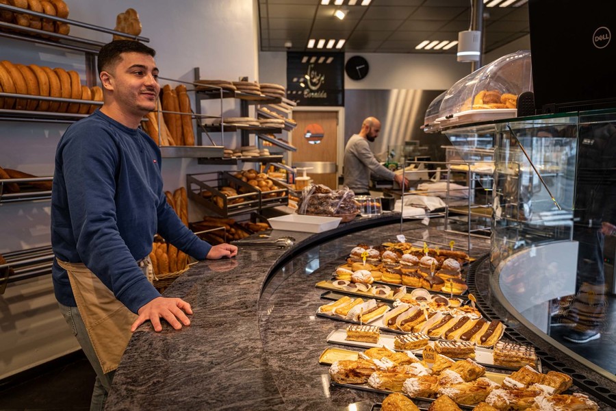 Twee medewerkers achter de bakkerstoog